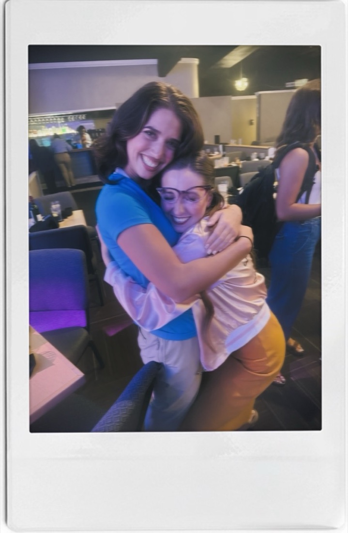 A polaroid of Beth Anderson and Cassie hugging and laughing