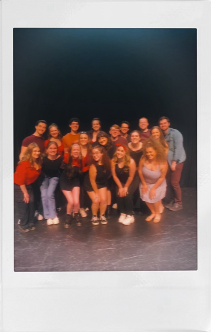 A polaroid of Beth Anderson and her graduating class gathered together on a bare stage